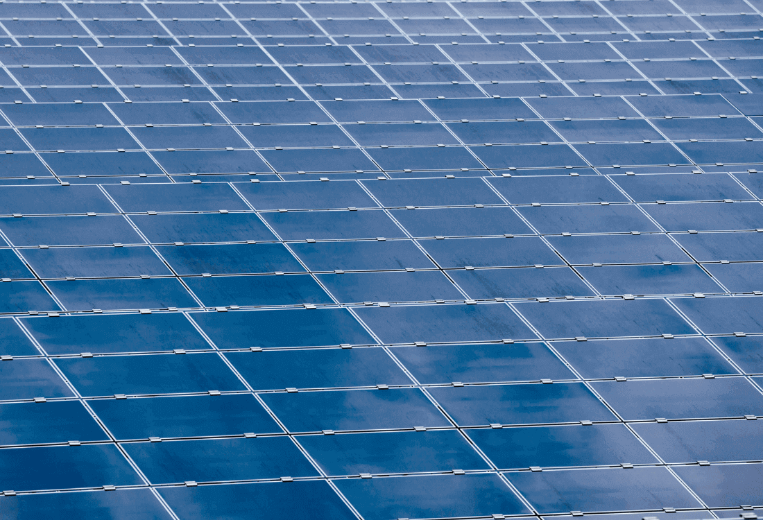 Wielkopowierzchniowa farma fotowoltaiczna. Niebieskie panele zamontowane ze pomocą klem do konstrukcji